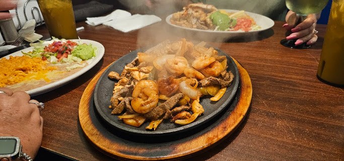 A fajita skillet arriving at the table
