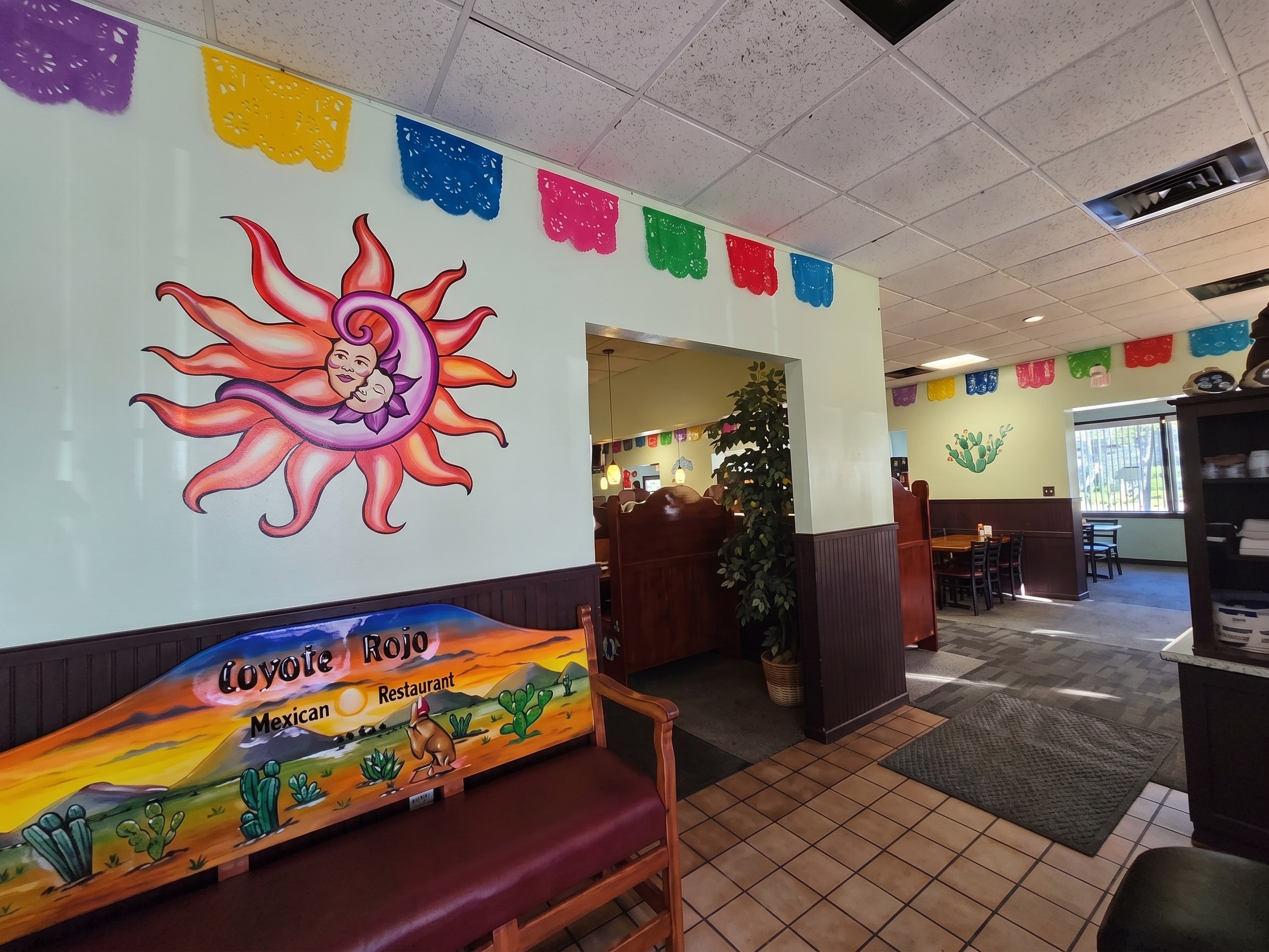 The painted sun on the wall, with papel picado overhead