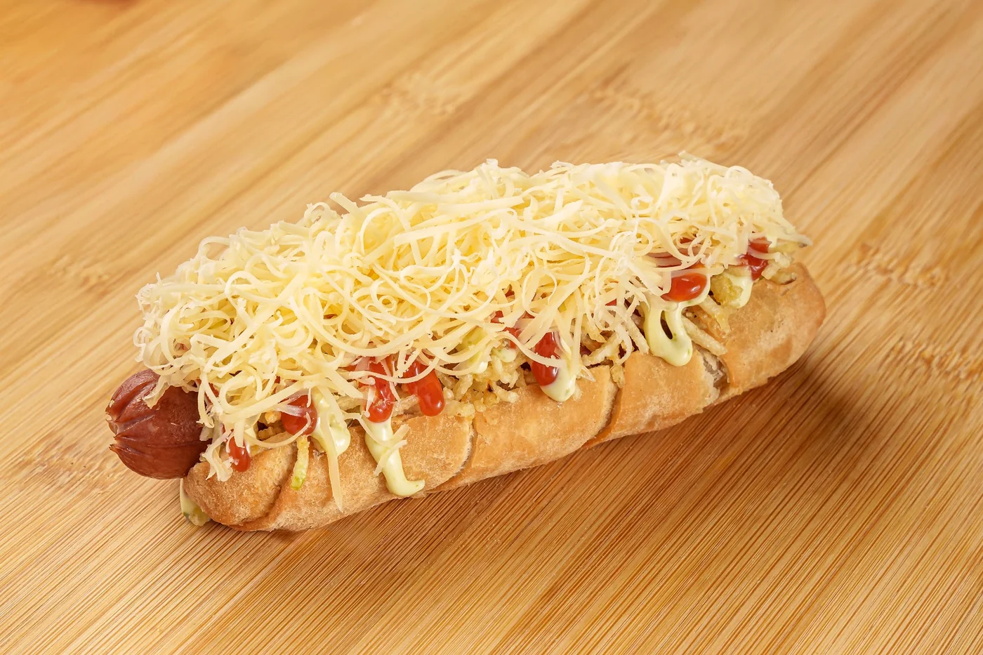 A hot dog topped with grated cheese.